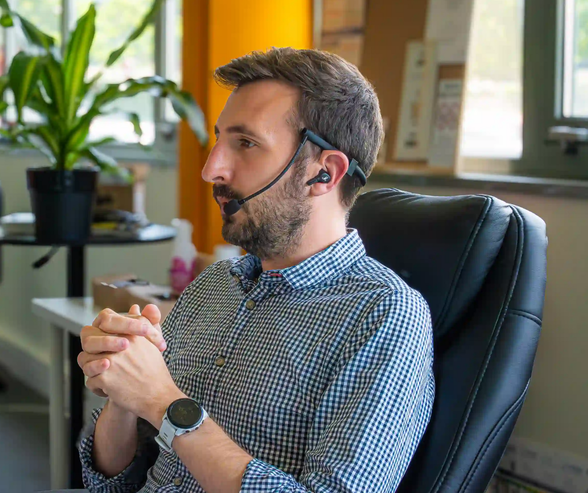 A person using the Aiphonia headset during a call at the office